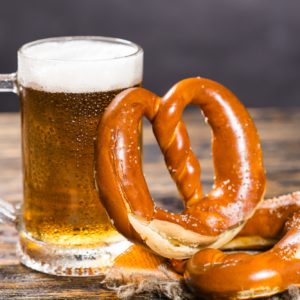 Food and drink concept - beer mug with german pretzel