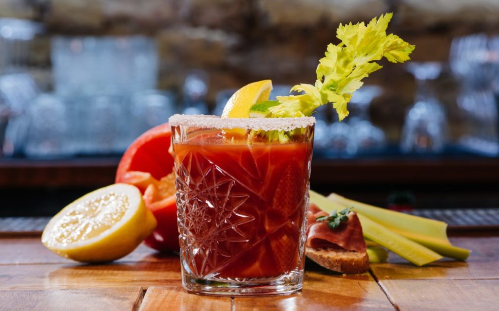 bloody mary cocktail in glass on wooden table