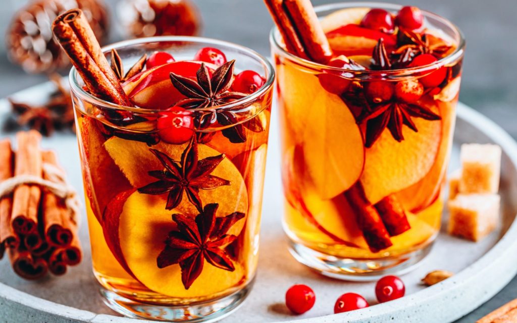 Apple cider mulled wine hot toddy or christmas punch in glass with fruits and spices