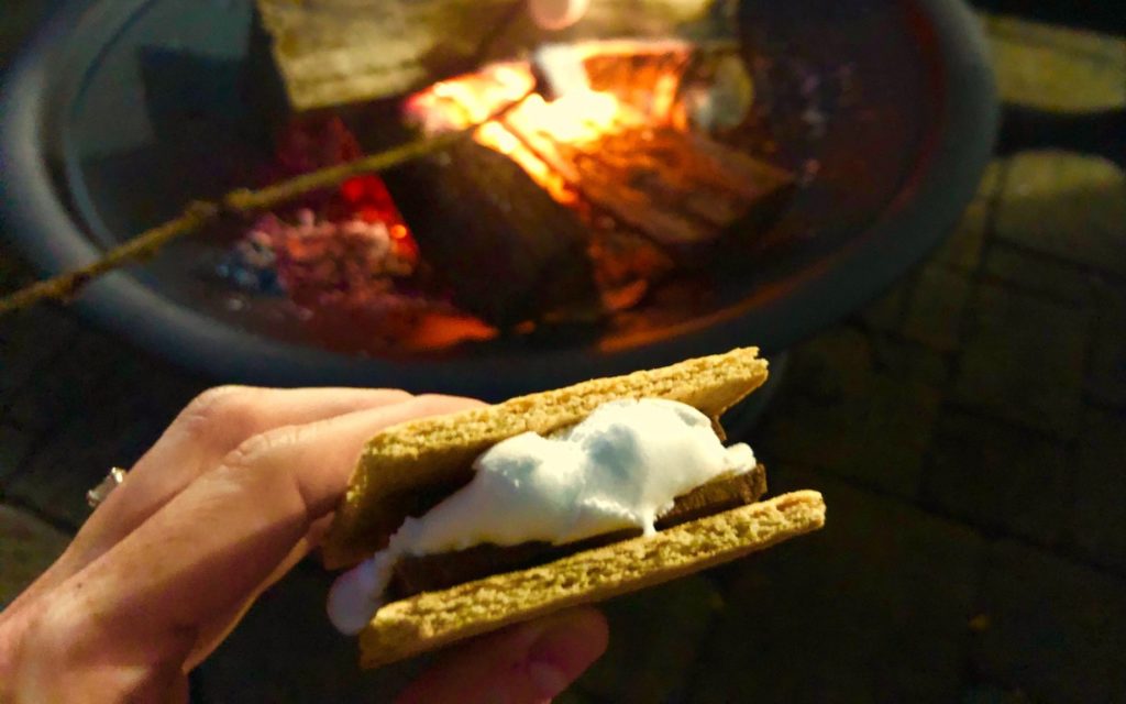 Making delicious gooey s’mores over a campfire